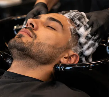 Client having his hair shampooed at the wash basin